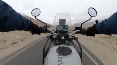 Ladakh dağlarında Himalyan bisikleti süren bir adam..