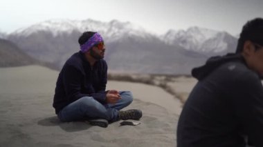 Üç arkadaş ladakh dağlarında yerde otururken sohbet ediyorlar. Yalnızken sohbet ediyorlar..
