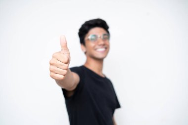 Genç Hintli çocuk beyaz izole bir arka planda kameraya başparmak gösteriyor. .