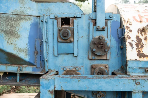 Mavi renge boyanmış eski paslı makineler güneş ışığı altında tutulur..