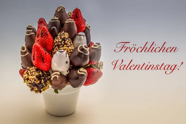 Almanca 'da Frochlichen Valentinstag yazan kırmızı harfli Sevgililer Günü tebrik kartı bir demet yenilebilir çiçek, beyaz üzerine izole edilmiş çikolatalı çilek aranjmanı.