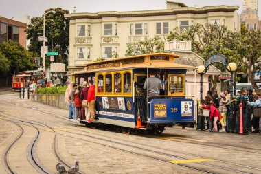 San Francisco, Kaliforniya / Amerika Birleşik Devletleri - 27 Mayıs 2013: Friedel Klussmann 's Wharf' taki nostaljik sarı ve mavi teleferikle seyahat eden insanlar
