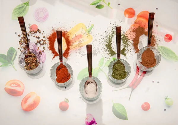 Renkli masa örtüsü üzerinde baharatlı çay kaşıkları, üst görünüm