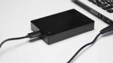 usb kablosu beyaz arkaplandaki taşınabilir bir sabit diske bağlanıyor