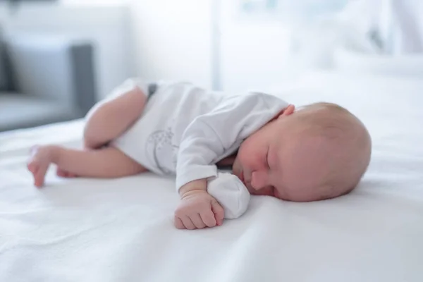 new born infant asleep in the blanket in delivery room