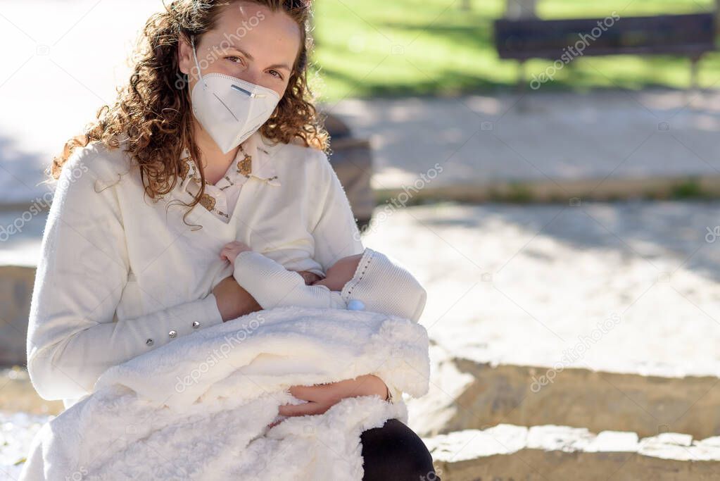 Mother breastfeeding her newborn baby in her arms while wearing surgical face mask sick concept during corona virus, covid-19 pandemic or allergy. Asian mommy sickness with child.