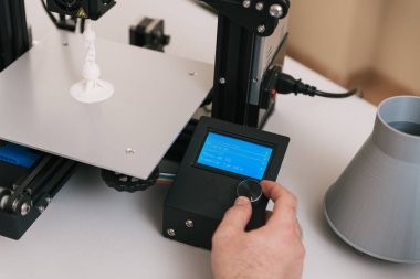Laboratuvardaki genç mühendis 3 boyutlu yazıcı bileşenlerini ayarlıyor.