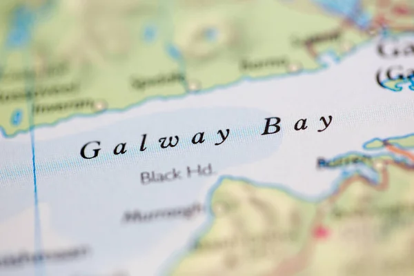 Shallow depth of field focus on geographical map location of Galway Bay off coast of Ireland on atlas