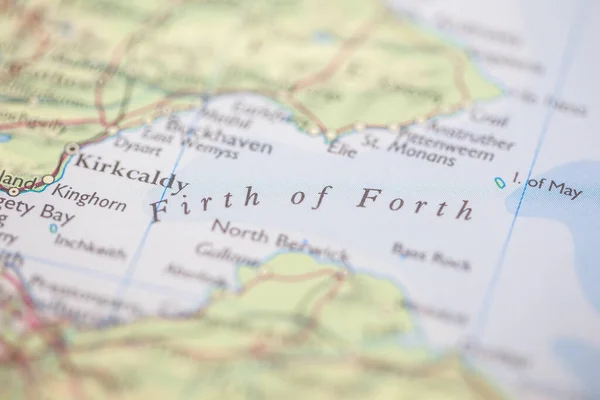 Shallow depth of field focus on geographical map location of Firth of Forth off coast of Scotland on atlas