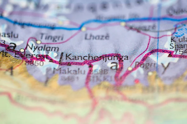 Shallow depth of field focus on geographical map location of Mount Kangchenjunga in Nepal Asia continent on atlas