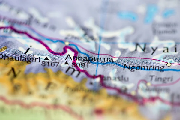 Shallow depth of field focus on geographical map location of Mount Annapurna in Nepal Asia continent on atlas