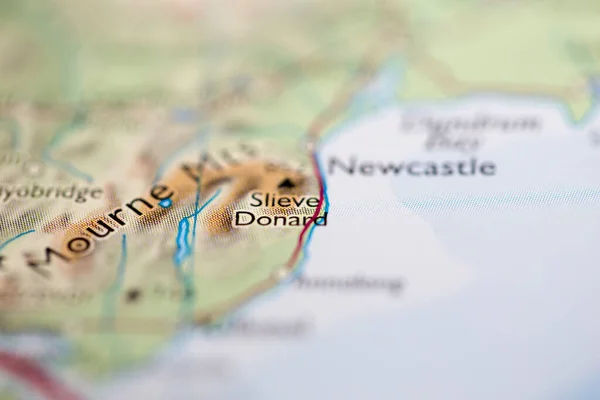 Shallow depth of field focus on geographical map location of Mount Slieve Donard in Northern Ireland Europe continent on atlas