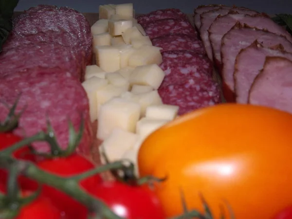 Peynirli, kırmızı, sarı domatesli ve kiraz domatesli dört çeşit füme sosis.