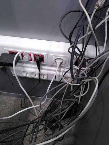 Fios elétricos de diferentes espessuras em tons de cinza no espaço de escritório — Fotografia de Stock