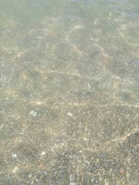 Küçük çakıl taşları ve su ile kıyı şeridi