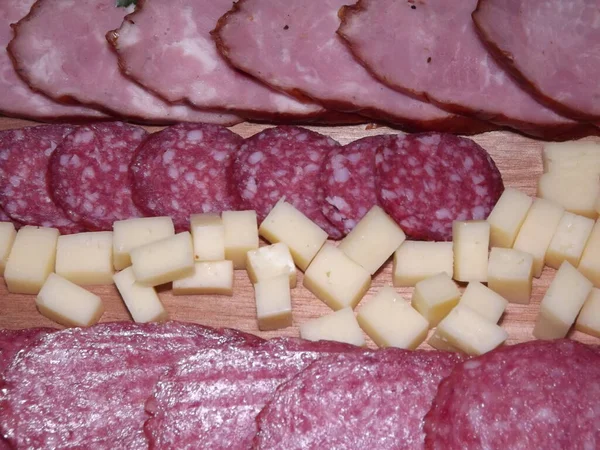 Fatias de salsicha defumada de quatro variedades com queijo e tomates vermelhos e amarelos e tomates cereja — Fotografia de Stock