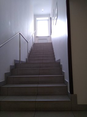 Yükselen merdivenlerin manzarası ve penceresinde güneş ışığı.