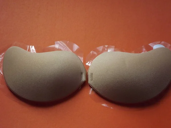 Beige strapless bra close-up on different color backgrounds, size A. — Stock Photo, Image