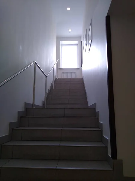 Yükselen merdivenlerin manzarası ve penceresinde güneş ışığı.