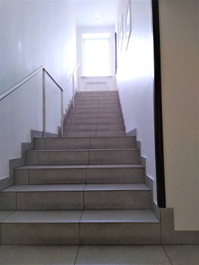 Yükselen merdivenlerin manzarası ve penceresinde güneş ışığı.