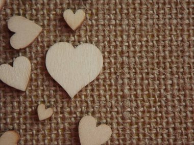 Sevgililer günü tebrik kartı olarak jüt kumaşında farklı boyutlarda tahta kalpler.