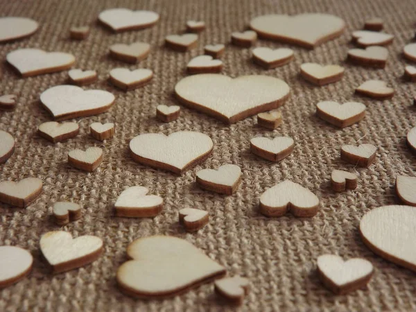 Coeurs en bois de différentes tailles sur tissu de jute comme une carte de voeux Saint-Valentin — Photo