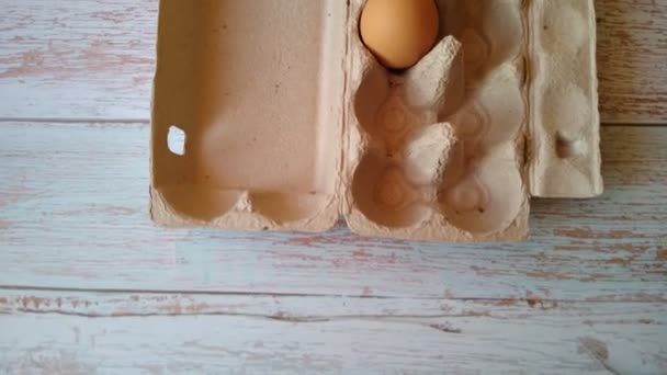 O mână de femeie ia un ou bej dintr-o cutie de ouă — Videoclip de stoc