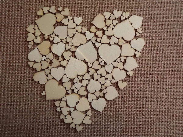 Holzherzen in verschiedenen Größen auf Jutestoff als Valentinstag-Grußkarte — Stockfoto