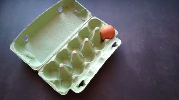 Женская рука берет бежевое яйцо из яичной коробки — стоковое видео