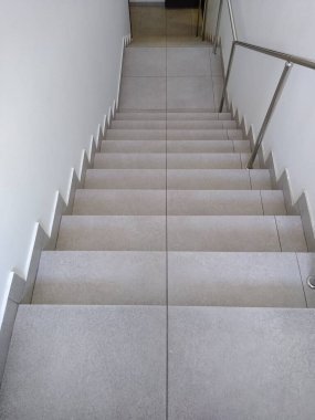 Üst kattan alt kattaki gri renge inen merdivenlerin görüntüsü