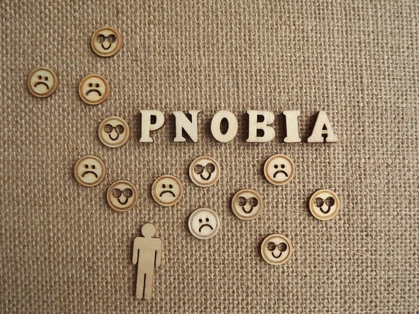 mental illness-phobia in the form of wooden letters and figures of people on a jute background