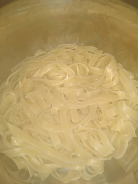 noodles, pasta cooked in a metal pot close-up