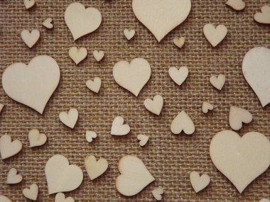 Sevgililer günü tebrik kartı olarak jüt kumaşında farklı boyutlarda tahta kalpler.