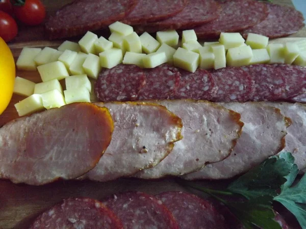 Fatias de salsicha defumada de quatro variedades com queijo e tomates vermelhos e amarelos e tomates cereja — Fotografia de Stock