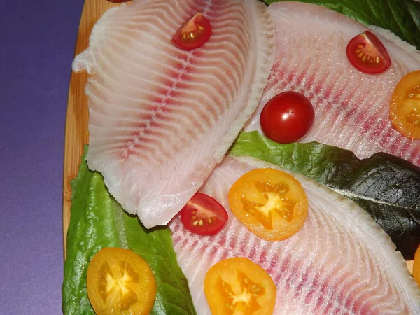 Domatesli, zeytinli ve marullu tilapia balığı filetosu pişirme işlemi — Stok fotoğraf