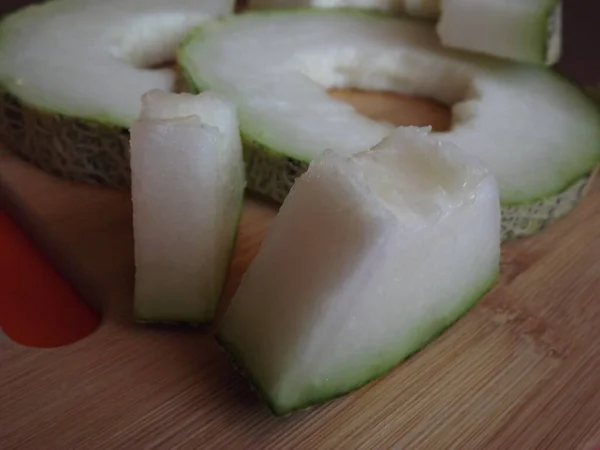 Ripe melon cut into slices on a wooden board — Stock Photo, Image