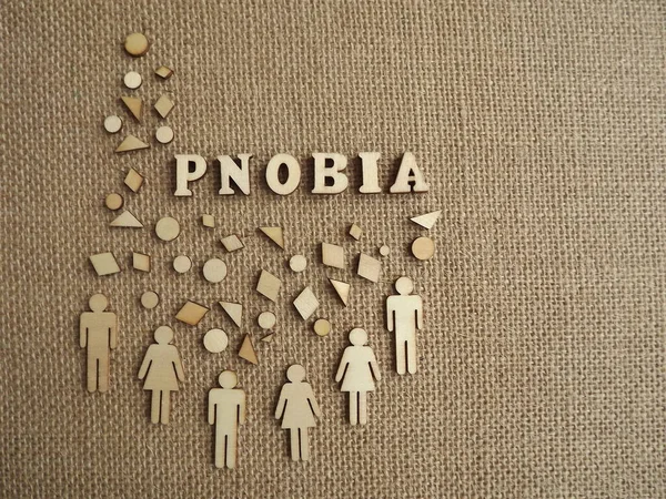 mental illness-phobia in the form of wooden letters and figures of people on a jute background