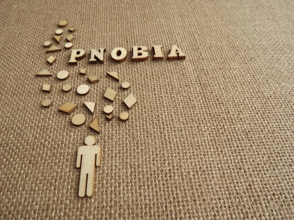 mental illness-phobia in the form of wooden letters and figures of people on a jute background