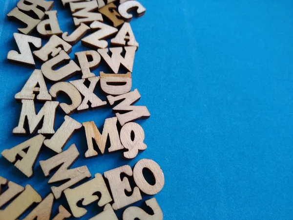 Trä bokstäver i alfabetet utspridda på en lila bakgrund med utrymme för text — Stockfoto