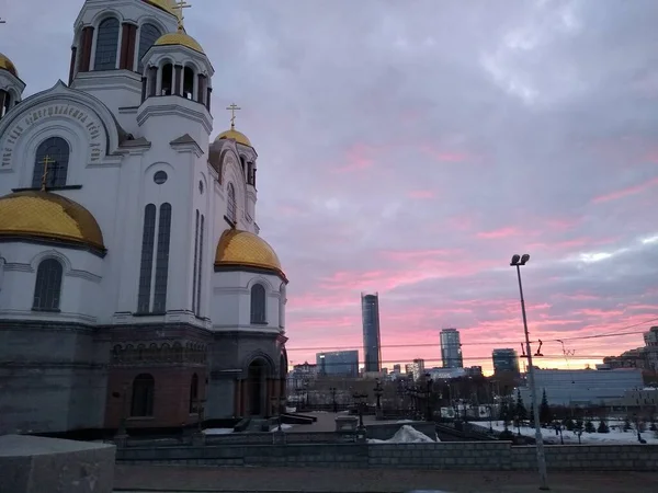 Ortodoxa kyrkan på bakgrunden av solnedgången i staden — Stockfoto