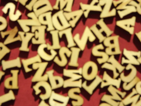 Träbokstäver i det engelska alfabetet på vinröd mocka som bakgrund — Stockfoto