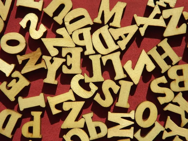 以勃艮第绒面革为背景的英文字母的木制字母 — 图库照片