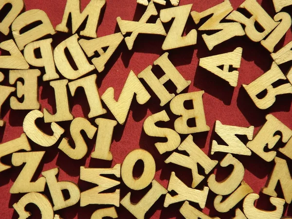 以勃艮第绒面革为背景的英文字母的木制字母 — 图库照片