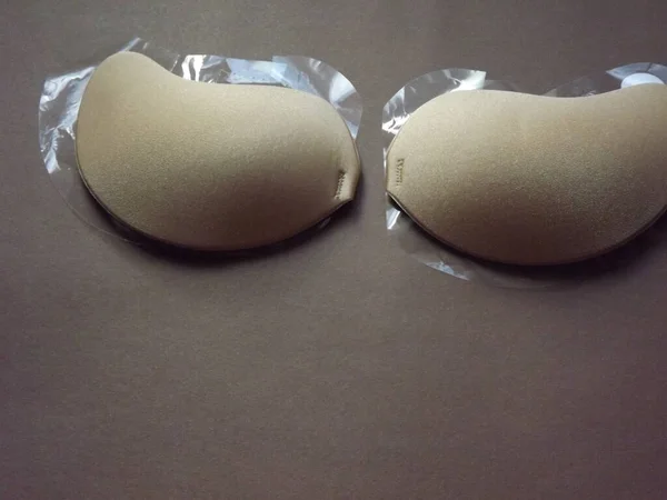 Beige strapless bra close-up on different color backgrounds, size A. — Stock Photo, Image