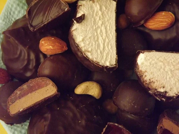 Doces de chocolate, marshmallows, marmelada e várias nozes close-up — Fotografia de Stock