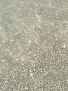 Küçük çakıl taşları ve su ile kıyı şeridi