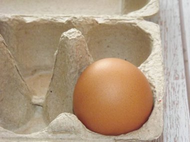 bej tavuk yumurtaları açık ahşap bir arka planda yumurta kutusunda