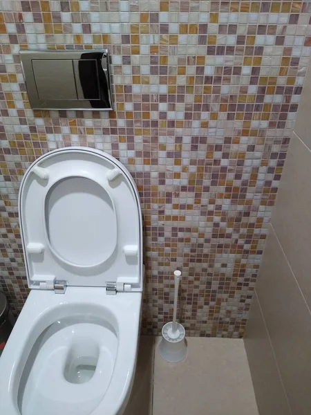 Унітаз в туалетній кімнаті з бежевою плиткою — стокове фото