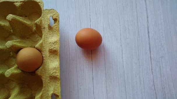 Una mano de mujer toma un huevo beige de una caja de huevos — Vídeos de Stock