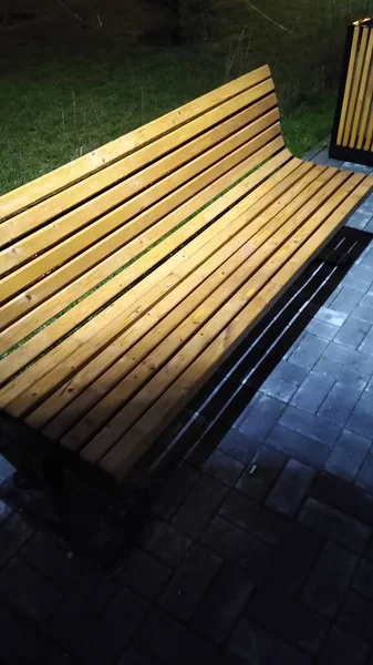 Drewniana ławka w parku nocnym wieczorem w deszczu zbliżenie — Zdjęcie stockowe